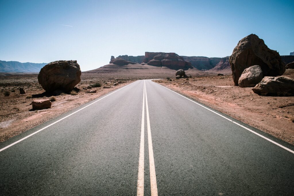 まっすぐなカントリーロードの写真。道路の中央に2本の中央線が引かれている。