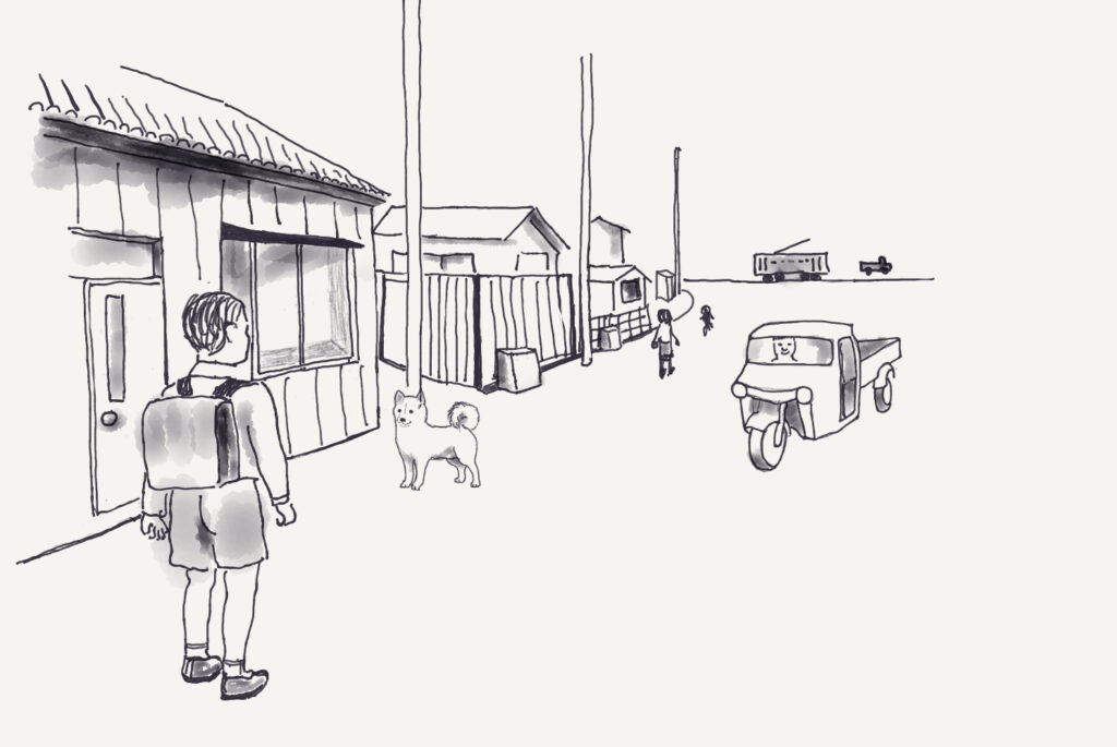 昭和30年代の家々が並ぶ静かな通りを通学する子どもの様子を、モノクロの線画で描いたものです。画の左手前には、ランドセルを背負い半ズボンをはいた子どもが家の前に立っています。木造の家の窓や玄関が見え、軒のある昔ながらの住宅の雰囲気が感じられます。家の前には一匹の犬が立ち、通りを見守るようにこちらを向いています。通りの奥には数軒の家が続き、電柱が立っています。画の右奥にはオート三輪トラックが走っています。さらに遠景には路面電車も描かれ、生活道路として使われている町の様子が表現されています。