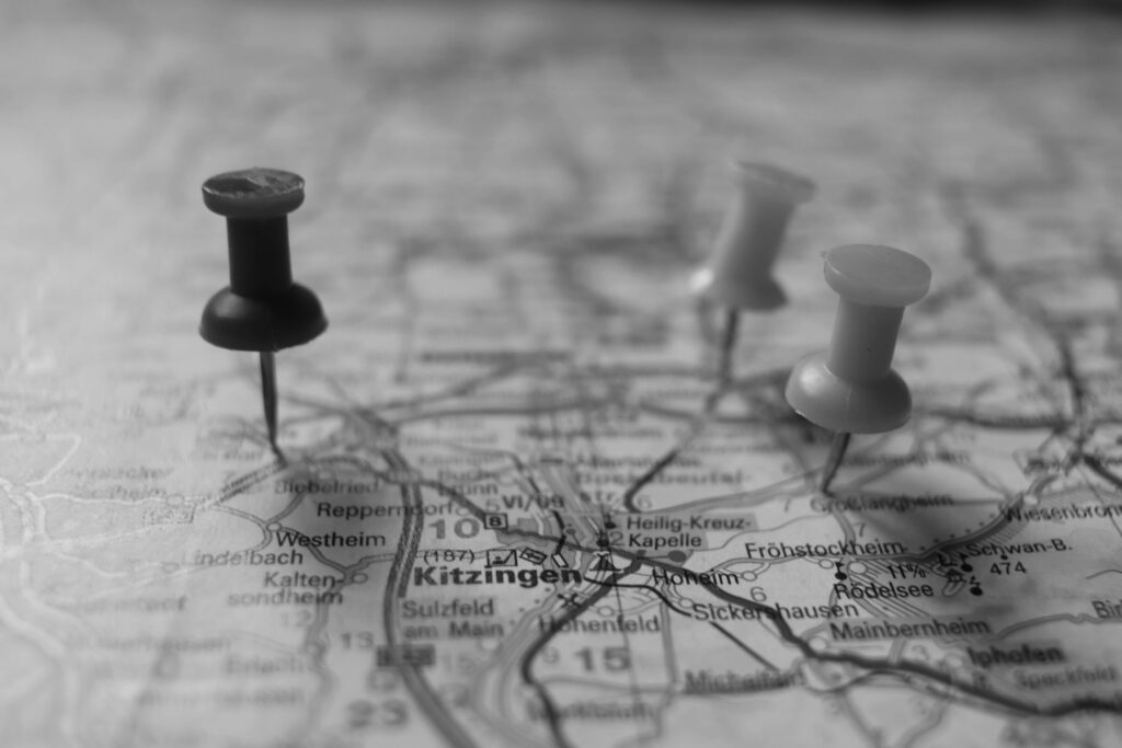 英語の地図にピンが3つ留められているモノクロの写真。